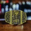 Skulls & Reaper Lighter Belt Buckle featuring intricate skull and reaper designs with an integrated brass-finish lighter.