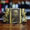Gambler Skulls With Hats Bronze Finish Belt Buckle with intricate skull designs and integrated brass-finish lighter