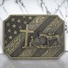 United States Flag Belt Buckle featuring a cowboy kneeling in front of a cross, crafted from polished zinc alloy.
