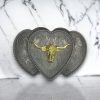 Vintage silver triple heart belt buckle with a golden longhorn centerpiece, perfect for Western-themed outfits.