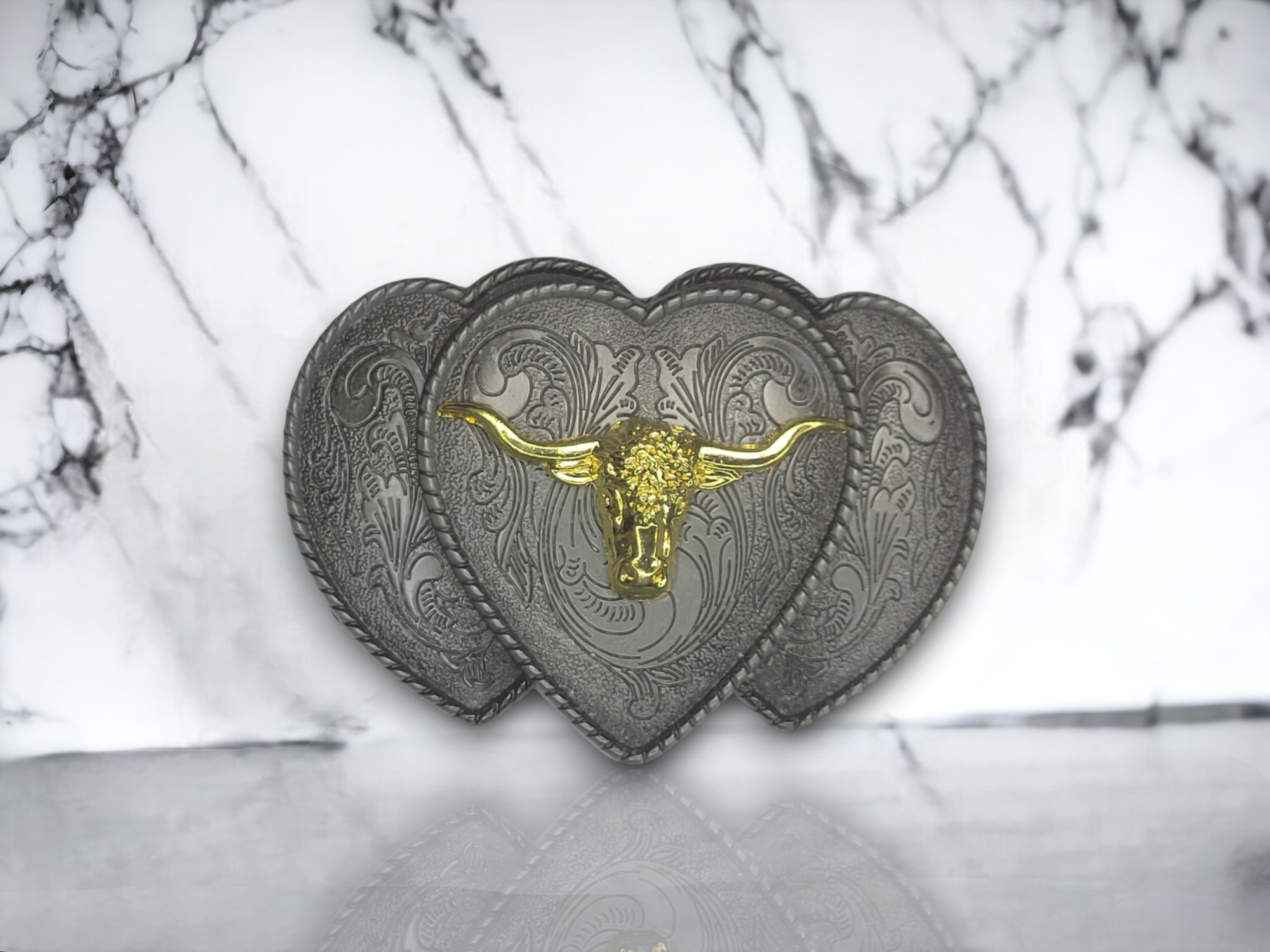 Vintage silver triple heart belt buckle with a golden longhorn centerpiece, perfect for Western-themed outfits.