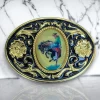 Western belt buckle featuring a cowboy riding a bronco, surrounded by a gold and black