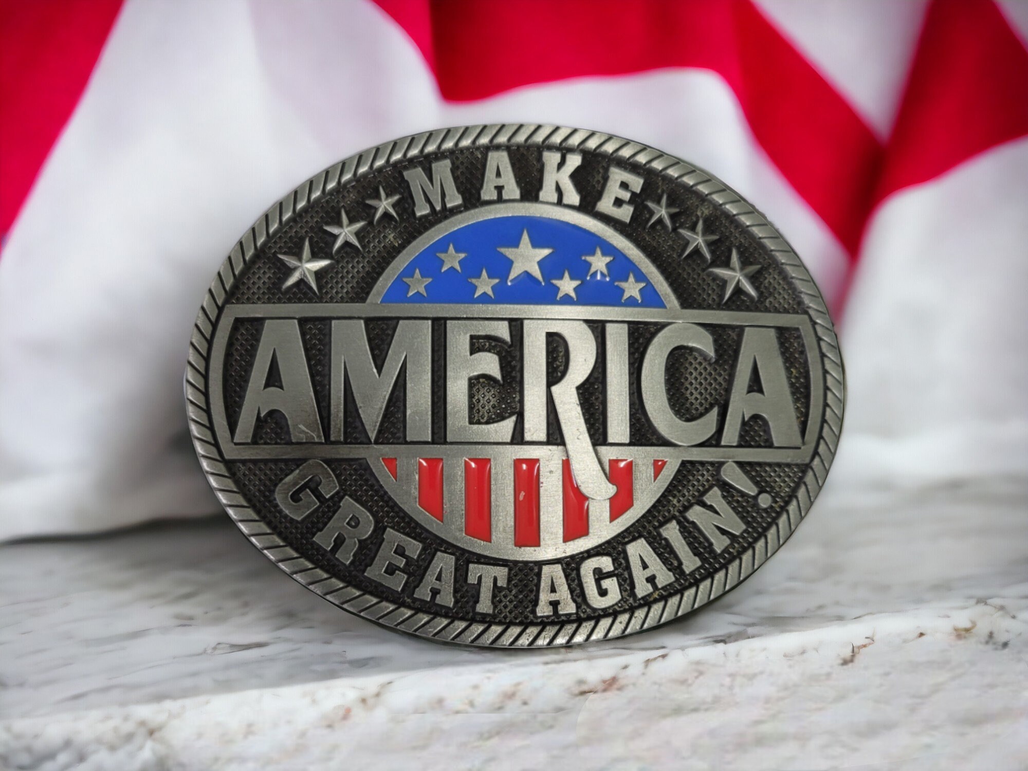 Silver-tone MAGA belt buckle with an American flag design, perfect for patriotic and Western wear.