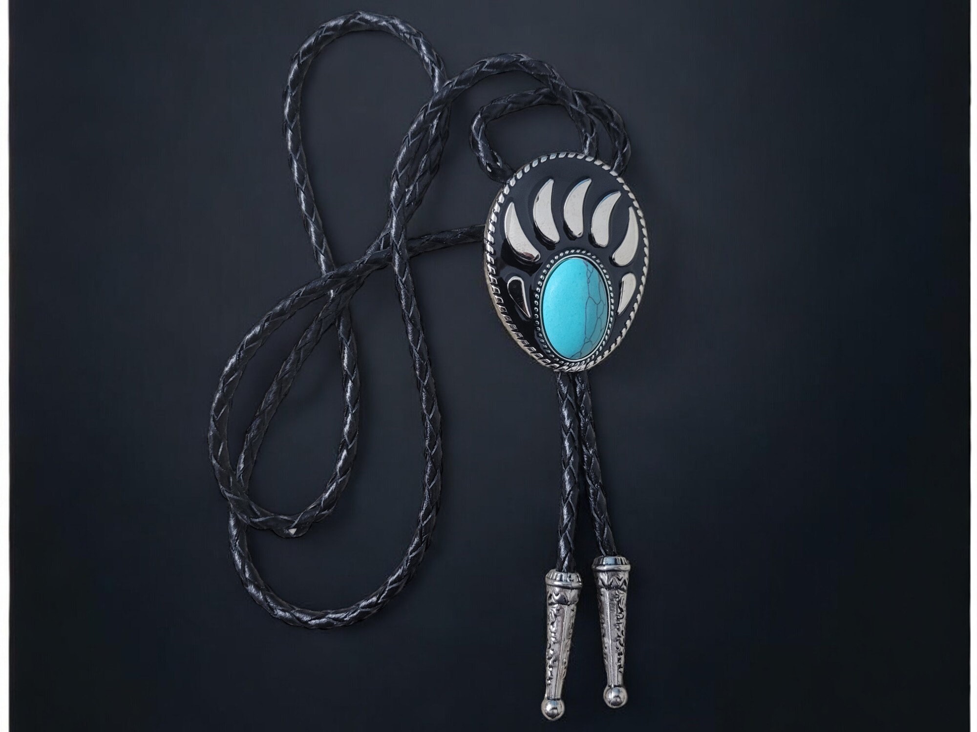 Western-style bear claw bolo tie with turquoise gemstone, braided leather cord, and metal tips.