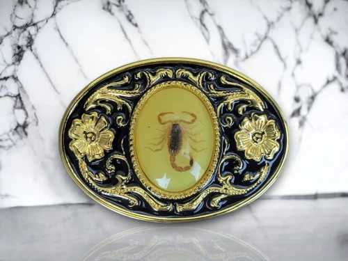 Western scorpion belt buckle with a real resin-covered scorpion, gold and black enamel floral design, and a rugged cowboy aesthetic.