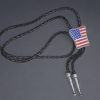 Guitar-shaped bolo tie with braided cowhide leather cord, metal tips, and adjustable slider clasp.