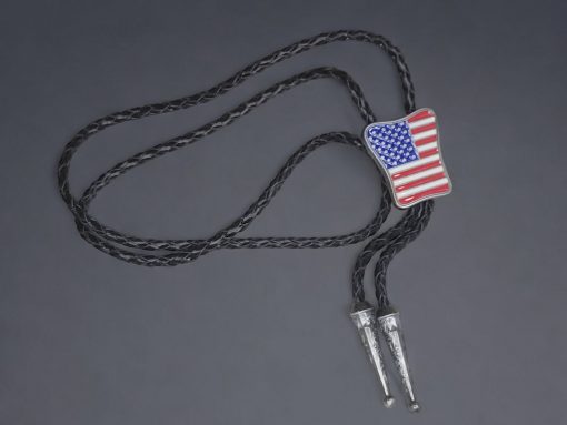 Guitar-shaped bolo tie with braided cowhide leather cord, metal tips, and adjustable slider clasp.