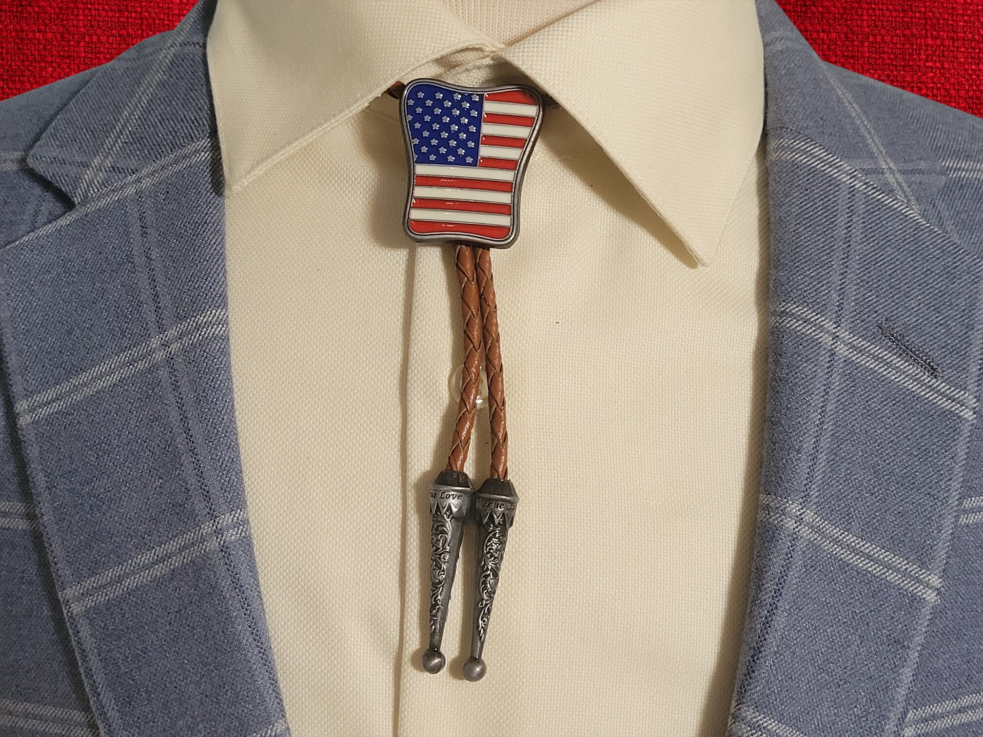 Western Wear Patirotic American Flag Bolo Tie With Genuine Cowhide Leather Cord (9) Western-style bolo tie with American flag design, braided leather cord, and metal tips.