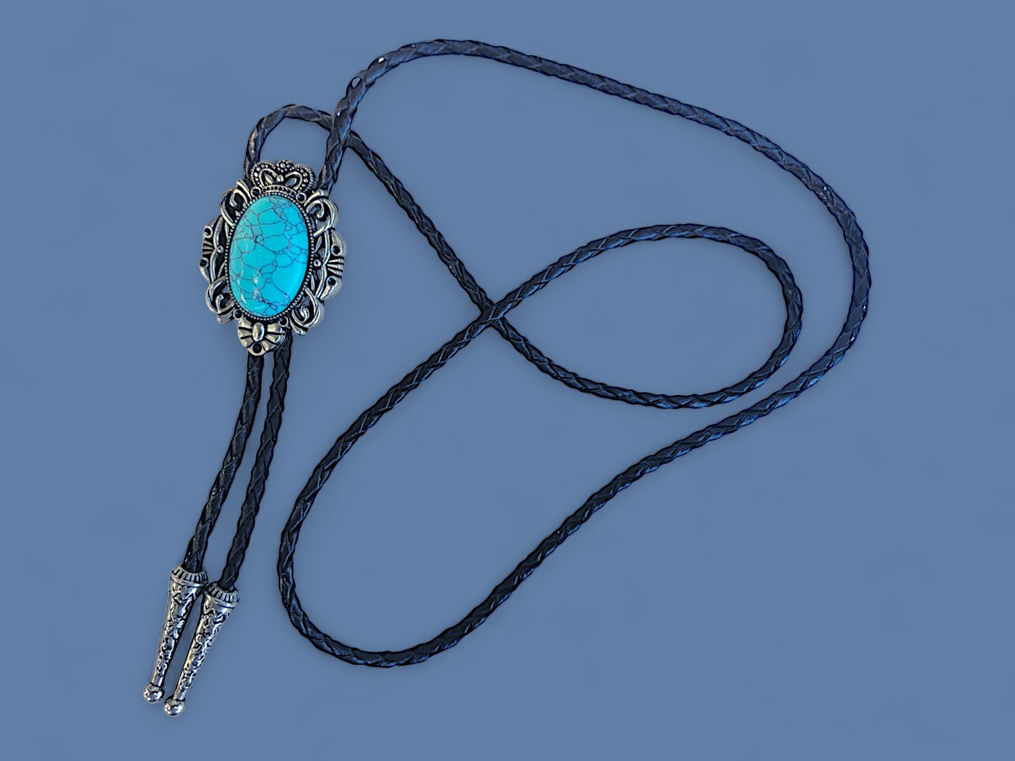 Western bolo tie with turquoise gemstone and vintage oval metal frame on braided leather cord